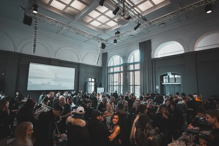 An audience seated in a hall watching a presentation